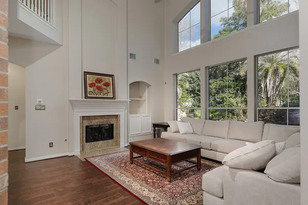 a living room with furniture a large window and a fireplace