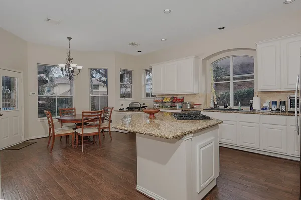 a kitchen with a counter top space a sink appliances and dining table
