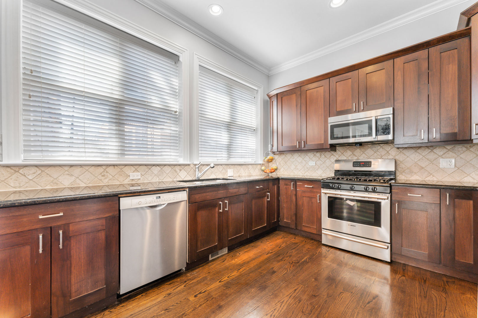 2060 North Stave Street, Unit 9 Chicago, IL 60647 - Photo 12 of 31 a kitchen with granite countertop wooden cabinets stainless steel appliances and a window