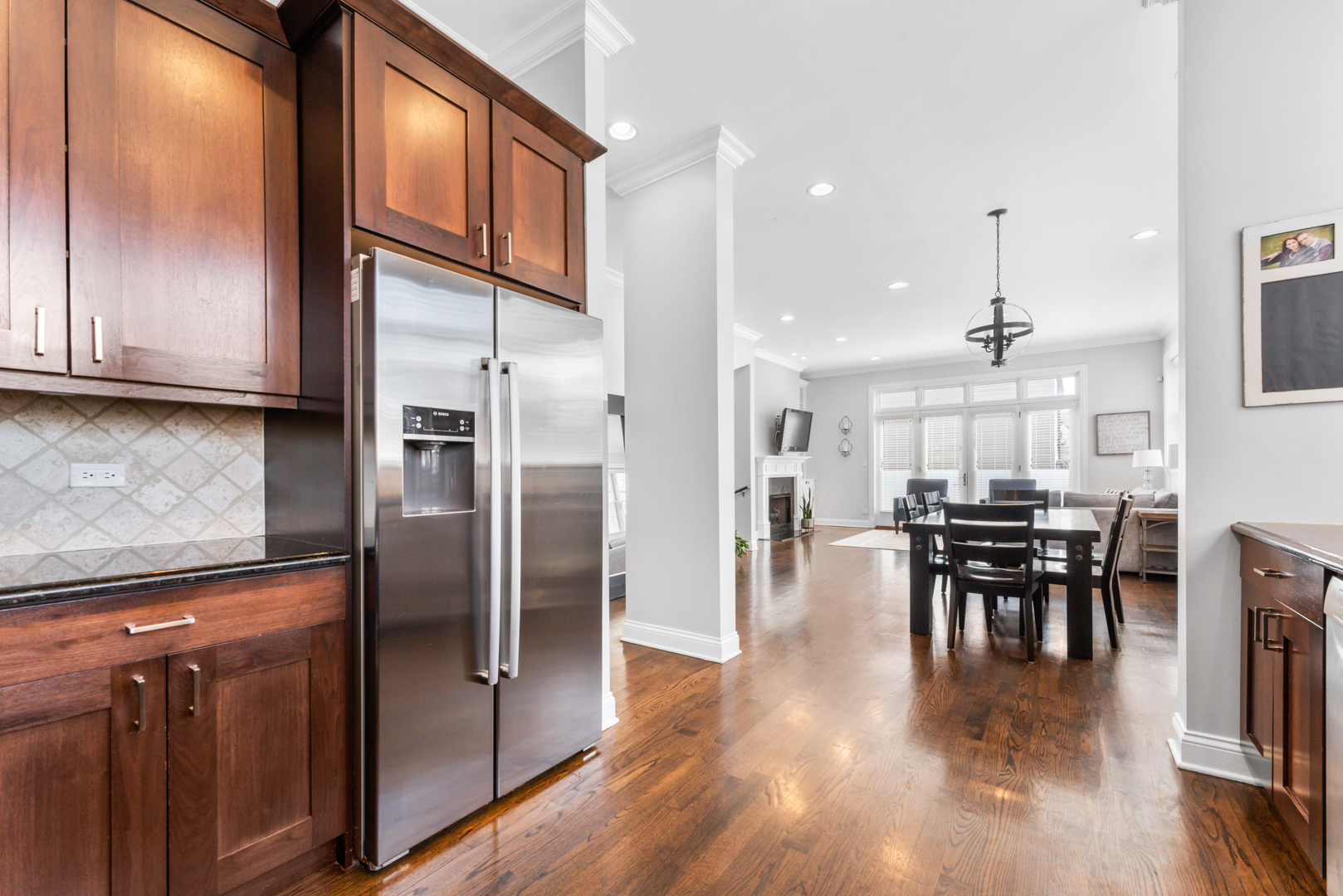 2060 North Stave Street, Unit 9 Chicago, IL 60647 - Photo 14 of 31 a kitchen with stainless steel appliances granite countertop wooden floor dining table and chairs