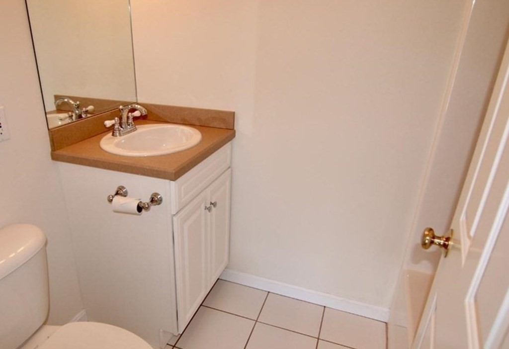 7 Conant Road, Unit 67 Winchester, MA 01890 - Photo 14 of 26 a bathroom with a sink and mirror with toilet