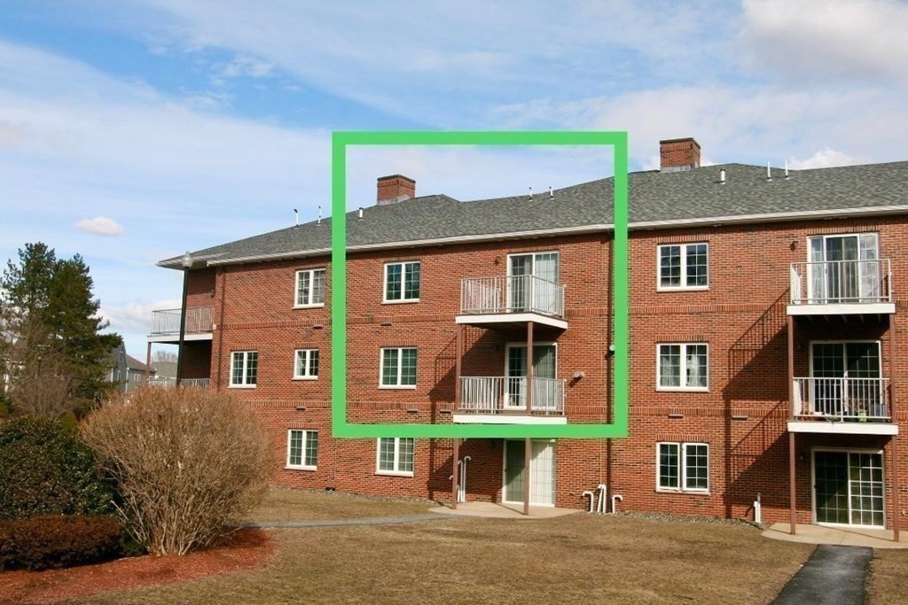 7 Conant Road, Unit 67 Winchester, MA 01890 - Photo 2 of 26 a front view of a house with a yard and garage