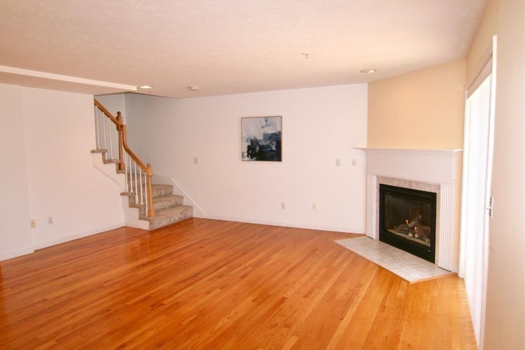 7 Conant Road, Unit 67 Winchester, MA 01890 - Photo 3 of 26 a view of empty room with wooden floor and fireplace