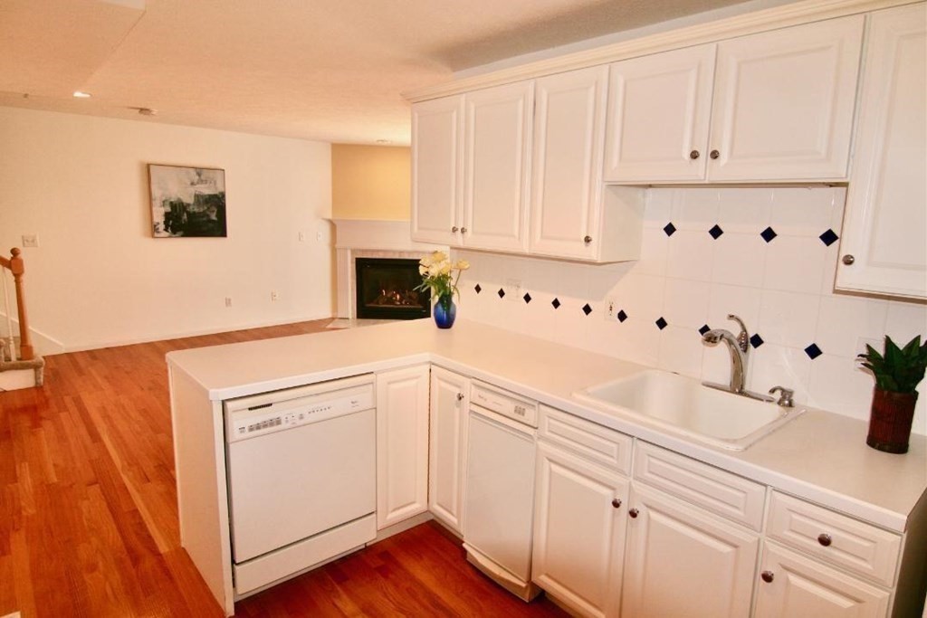 7 Conant Road, Unit 67 Winchester, MA 01890 - Photo 4 of 26 a kitchen with white cabinets and white appliances