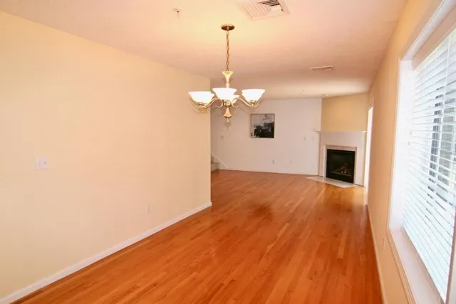 a view of a room with wooden floor and chandelier