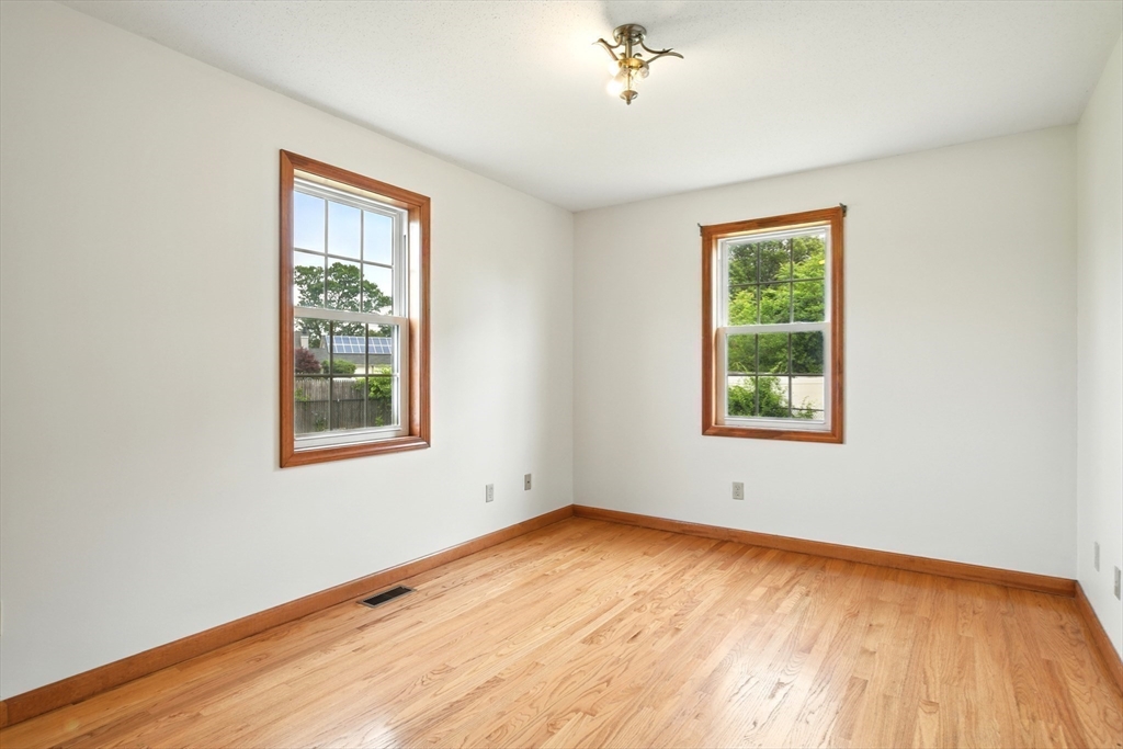 254 Island Pond Road Springfield, MA 01118 - Photo 18 of 26 an empty room with wooden floor and windows