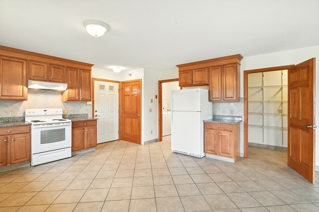 254 Island Pond Road Springfield, MA 01118 - Photo 6 of 26 a kitchen with granite countertop a refrigerator and a stove top oven