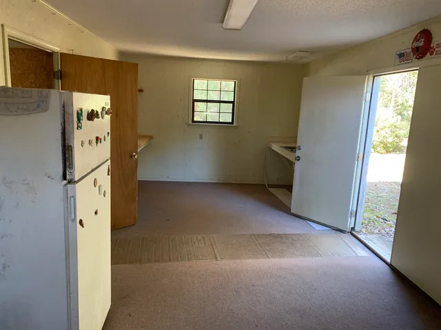 a view of hallway with window and refrigerator