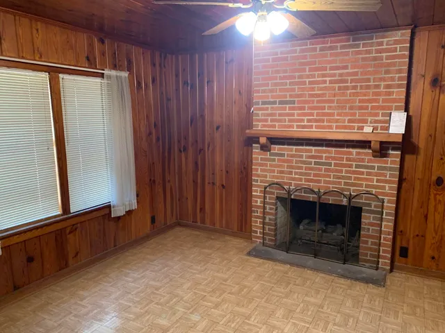 a view of an empty room with a fireplace and a window