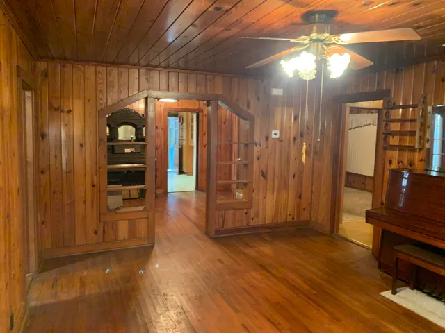 a view of a hallway with wooden floor and furniture