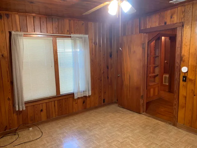 an empty room with wooden floor and a window