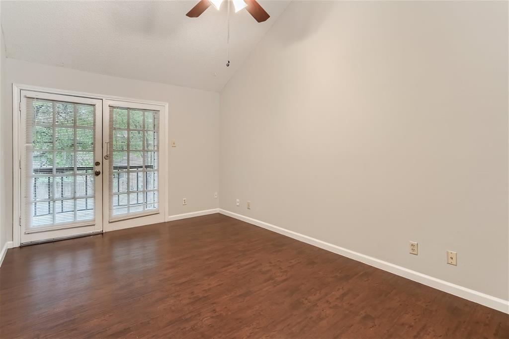 16301 Ledgemont Lane, Unit 269 Addison, TX 75001 - Photo 9 of 22 an empty room with wooden floor and windows