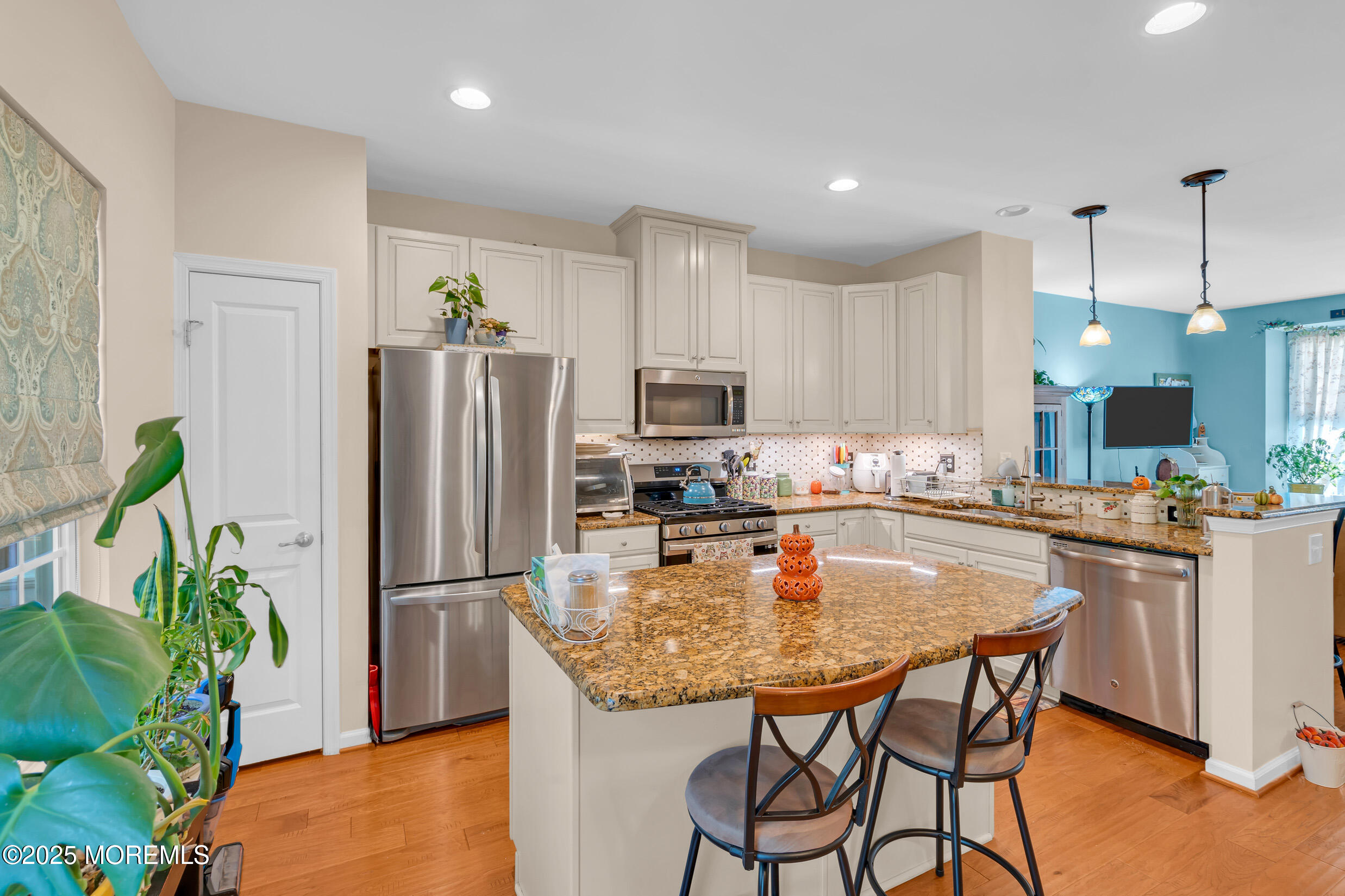 111 Spirit Way Brick, NJ 08723 - Photo 12 of 39 a kitchen with stainless steel appliances granite countertop a refrigerator a stove a sink a microwave a dining table and chairs with wooden floor