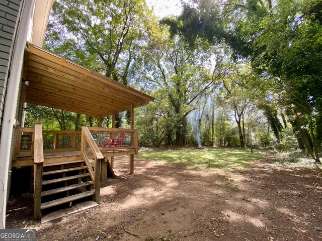 a backyard of a house with barbeque oven and table and chairs