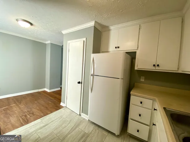 a bedroom with a refrigerator and a stove top oven