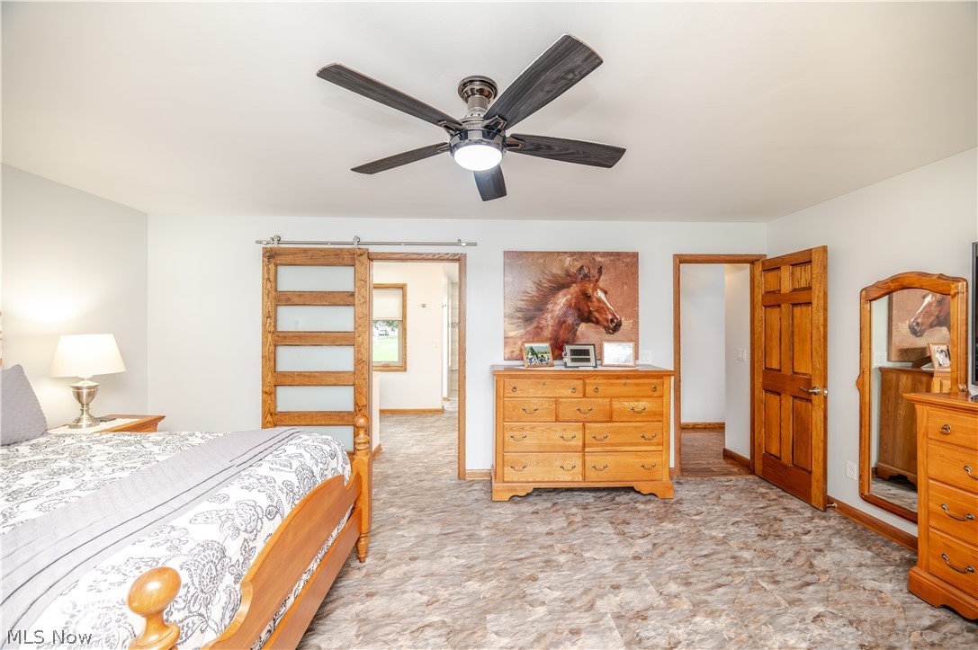405 Airport Road Northwest Warren, OH 44481 - Photo 23 of 50 Spacious room featuring ceiling fan, and a barn door with frosted glass panels