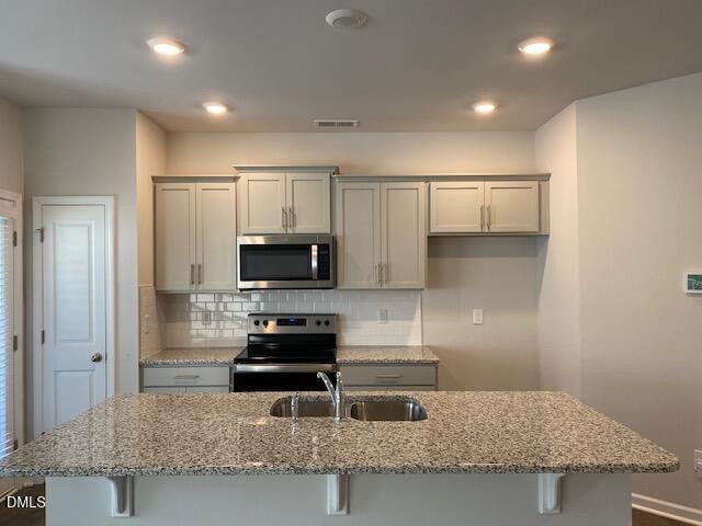 1278 Adrian Court Mebane, NC 27302 - Photo 16 of 33 a kitchen with granite countertop a stove and a sink