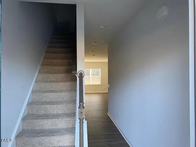 a view of staircase with white walls and white door