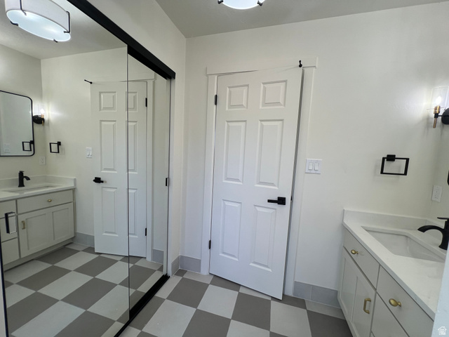 812 East Bates Cyn Road Tooele, UT 84074 - Photo 57 of 144 Bathroom featuring a checkered tile floor, dual vanity sinks with light countertops, and white cabinetry