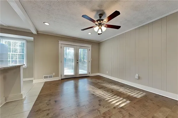 a view of an empty room with wooden floor and a window