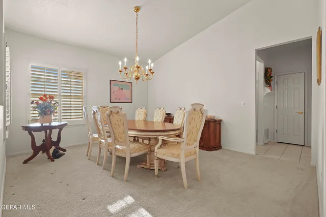 a dining room with furniture a chandelier and window