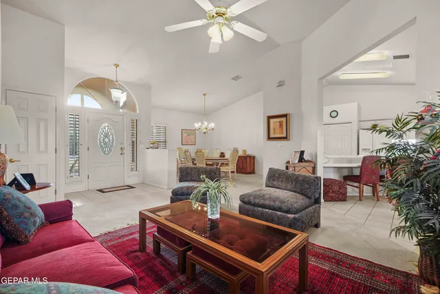 a living room with furniture a chandelier and a rug