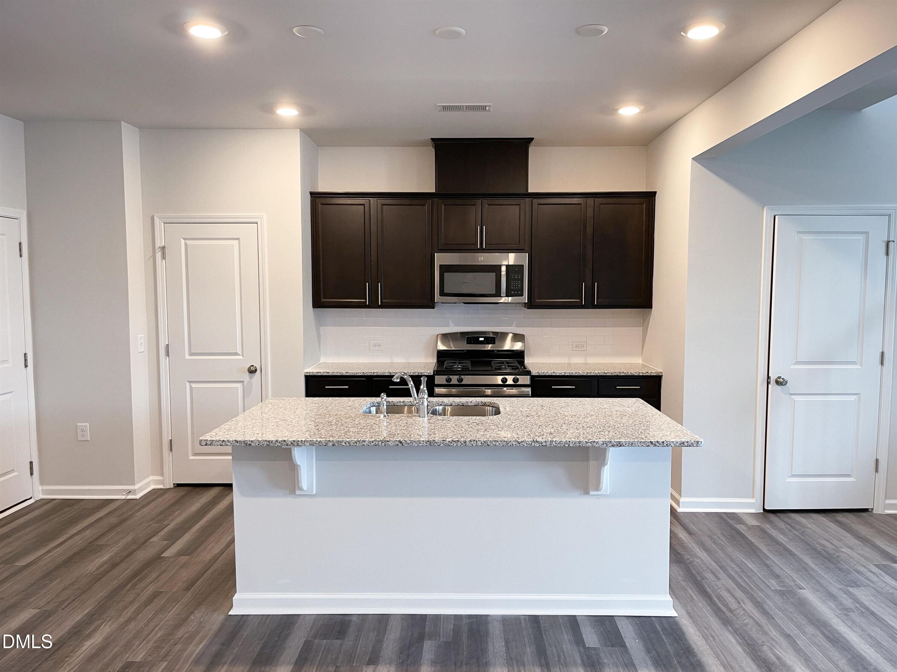 6525 Mezzo Lane Raleigh, NC 27616 - Photo 8 of 38 a large kitchen with stainless steel appliances a large counter top a stove and a wooden floors