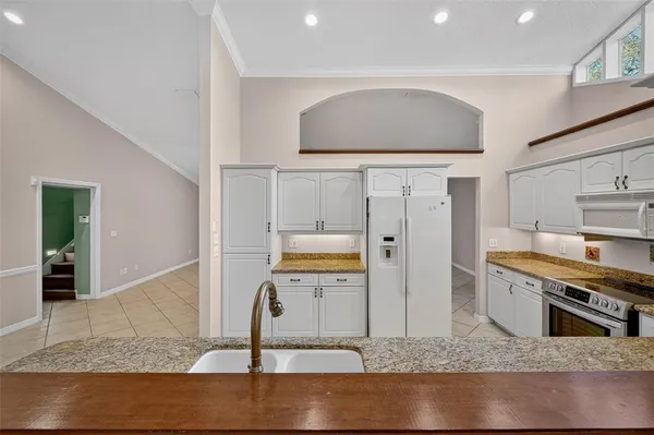 a view of an empty room with window and chandelier fan