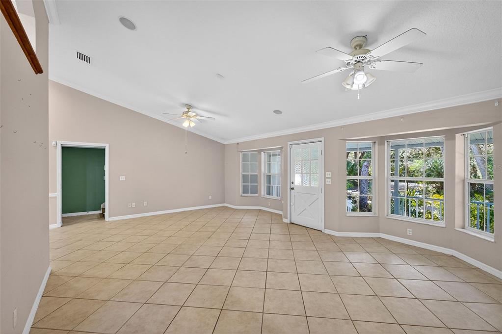 4875 Sailfish Drive Ponce Inlet, FL 32127 - Photo 18 of 60 a view of an empty room with window and chandelier fan
