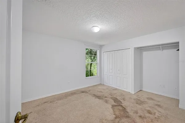 a view of an empty room with window and hardwood floor