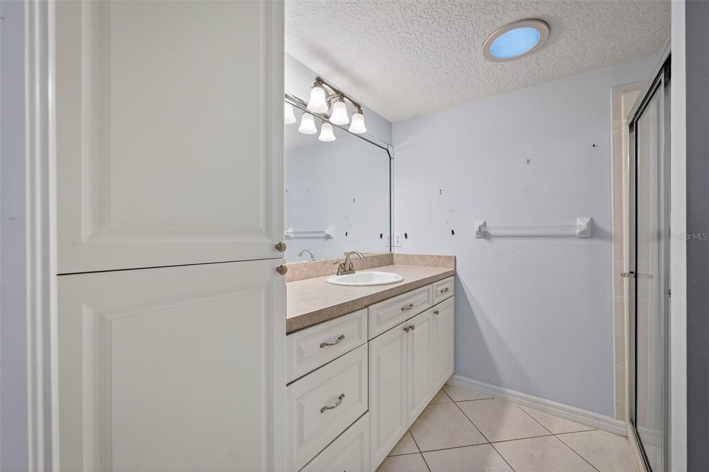 4875 Sailfish Drive Ponce Inlet, FL 32127 - Photo 25 of 60 a bathroom with a double vanity sink and a mirror