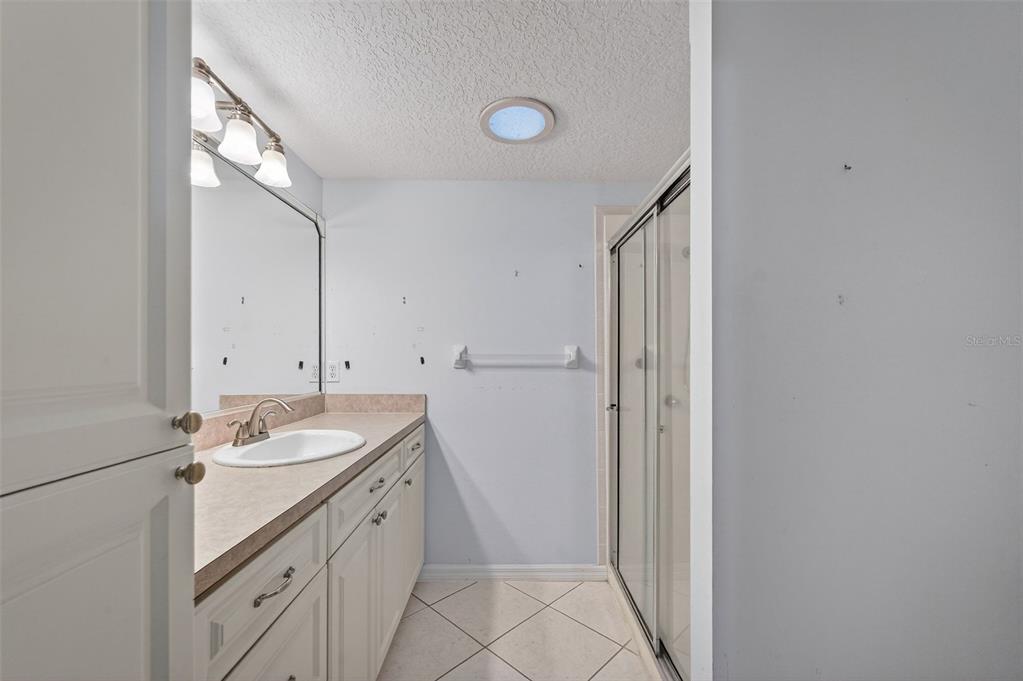 4875 Sailfish Drive Ponce Inlet, FL 32127 - Photo 26 of 60 a spacious bathroom with a granite countertop sink and a mirror