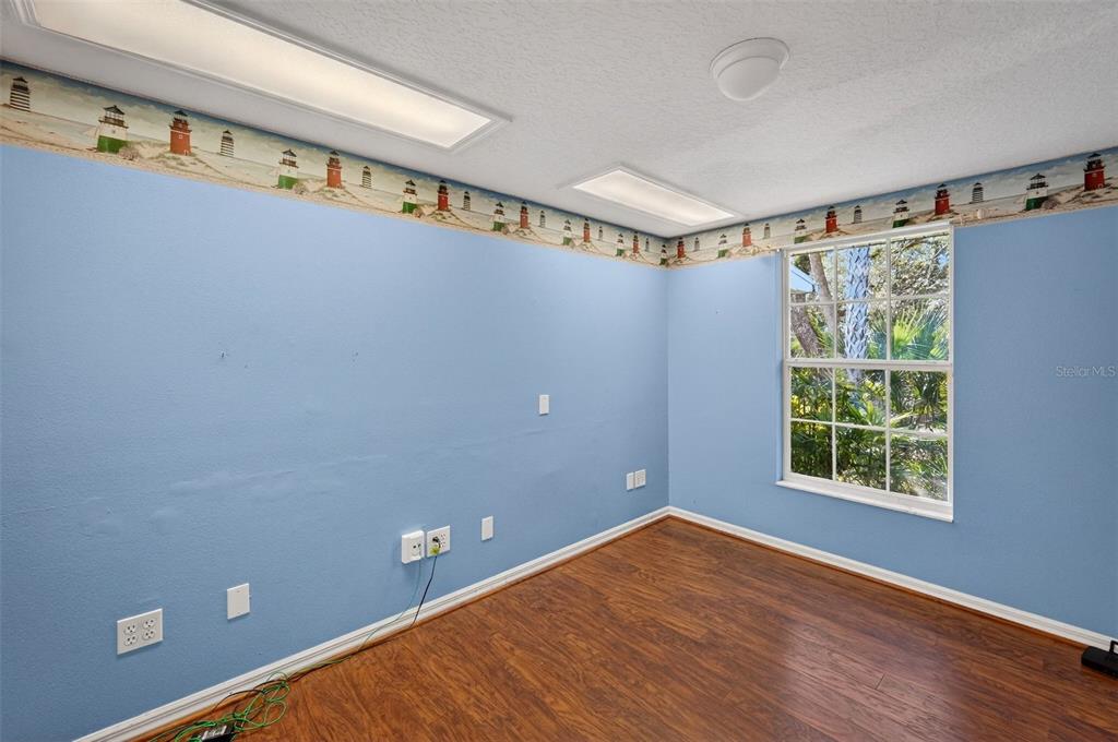 4875 Sailfish Drive Ponce Inlet, FL 32127 - Photo 28 of 60 a view of an empty room with window and hardwood floor