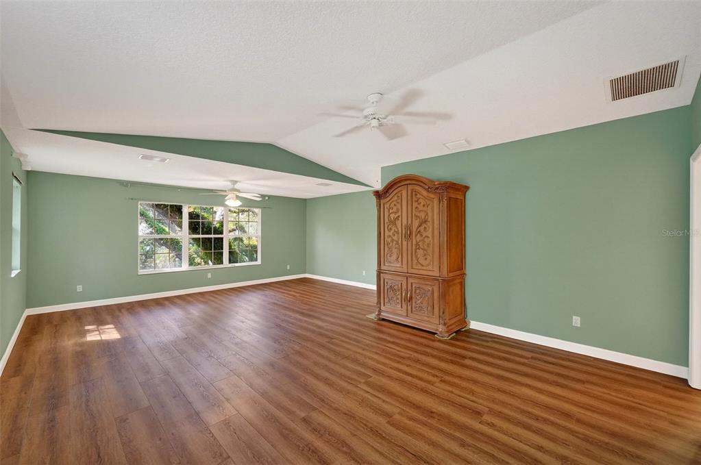 4875 Sailfish Drive Ponce Inlet, FL 32127 - Photo 39 of 60 an empty room with wooden floor and windows
