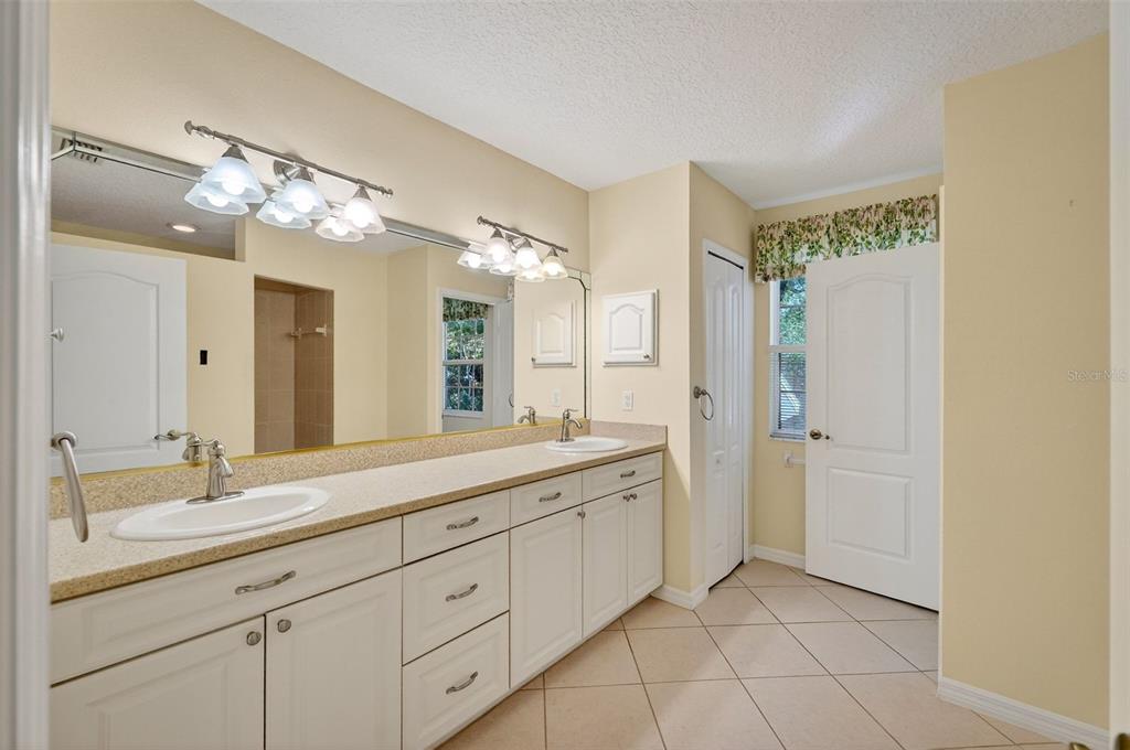 4875 Sailfish Drive Ponce Inlet, FL 32127 - Photo 41 of 60 a spacious bathroom with a double vanity sink and a mirror
