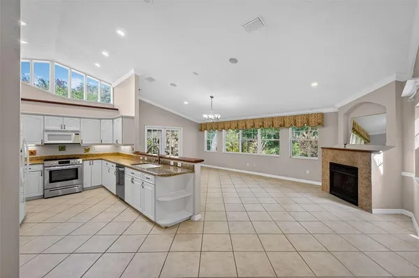 a large kitchen with granite countertop a stove and a sink