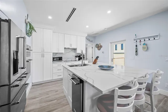 a kitchen with granite countertop a sink appliances cabinets and counter space