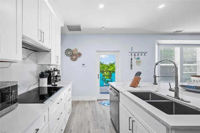 a kitchen with granite countertop a sink and a stove top oven