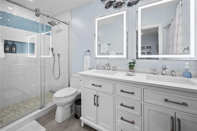 a bathroom with a granite countertop sink toilet and shower