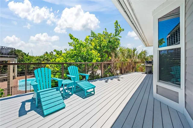 a view of a balcony with wooden floor and iron fence