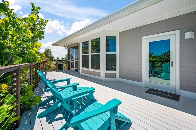 a view of a patio with table and chairs with wooden floor and fence