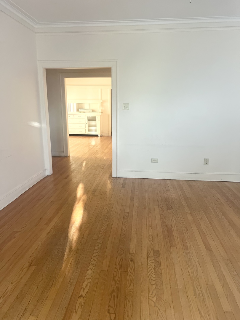 7955 South Morgan Street Chicago, IL 60620 - Photo 2 of 5 an empty room with wooden floor and windows