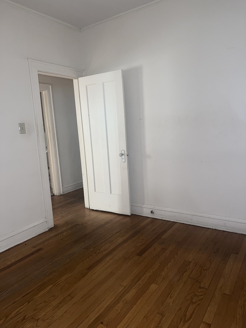 7955 South Morgan Street Chicago, IL 60620 - Photo 3 of 5 a view of an empty room with wooden floor