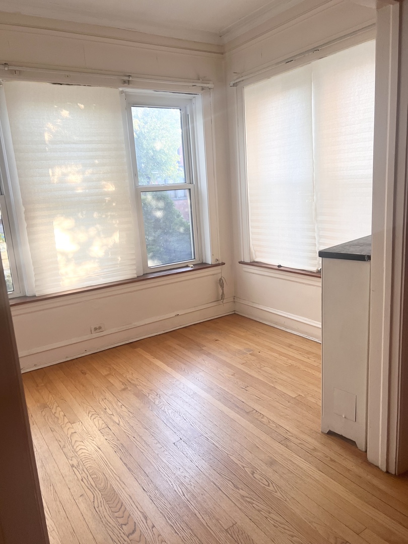 7955 South Morgan Street Chicago, IL 60620 - Photo 4 of 5 an empty room with wooden floor and windows