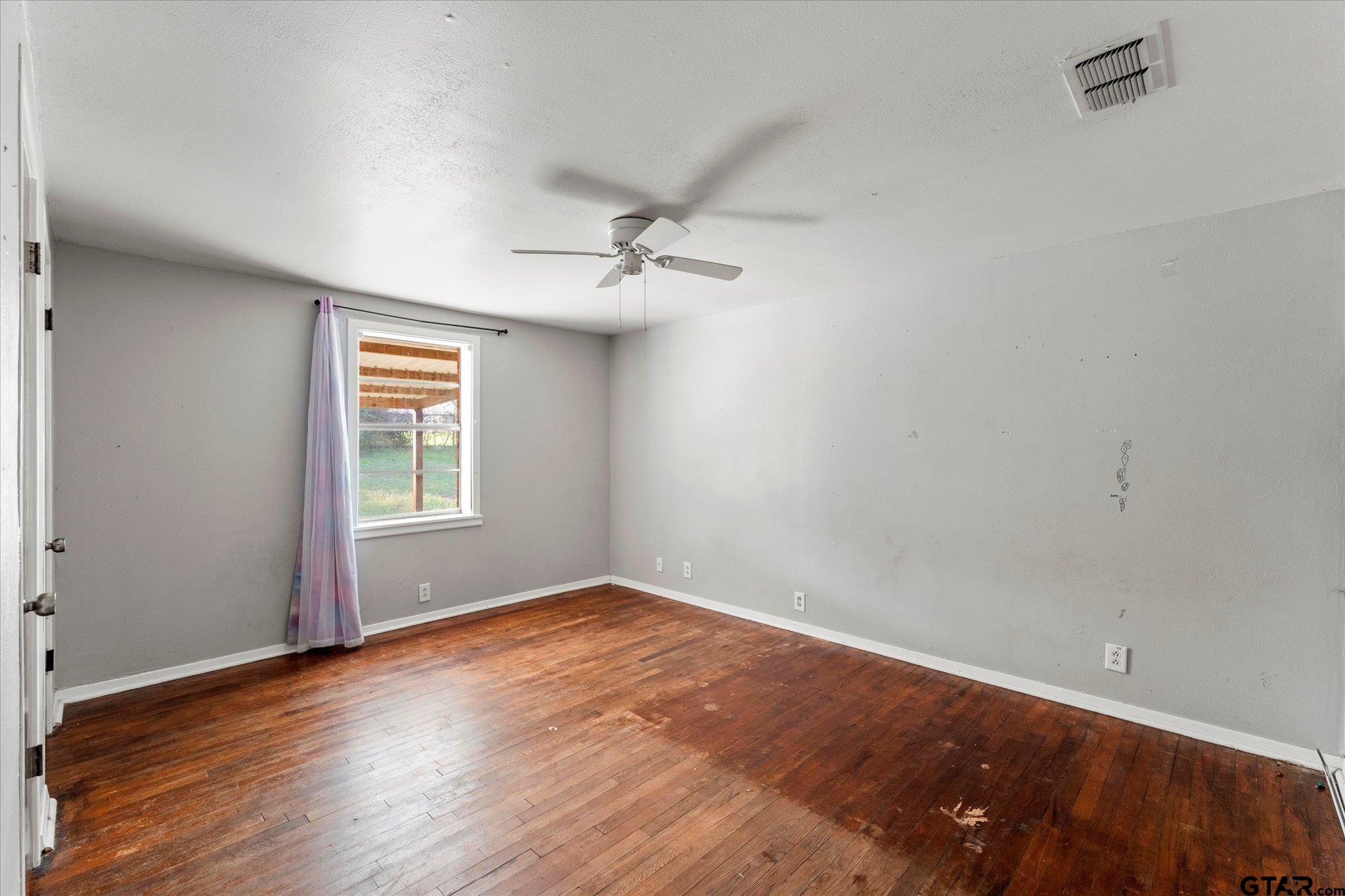 1108 Merritt Avenue Mount Pleasant, TX 75455 - Photo 14 of 17 wooden floor in an empty room with a window