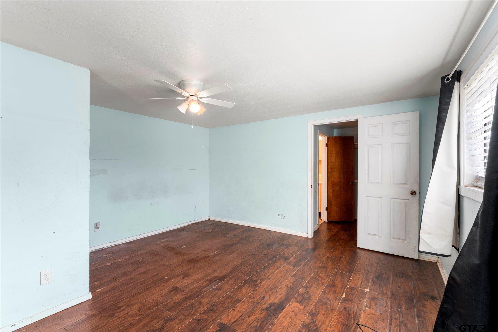 1108 Merritt Avenue Mount Pleasant, TX 75455 - Photo 17 of 17 an empty room with wooden floor and a ceiling fan