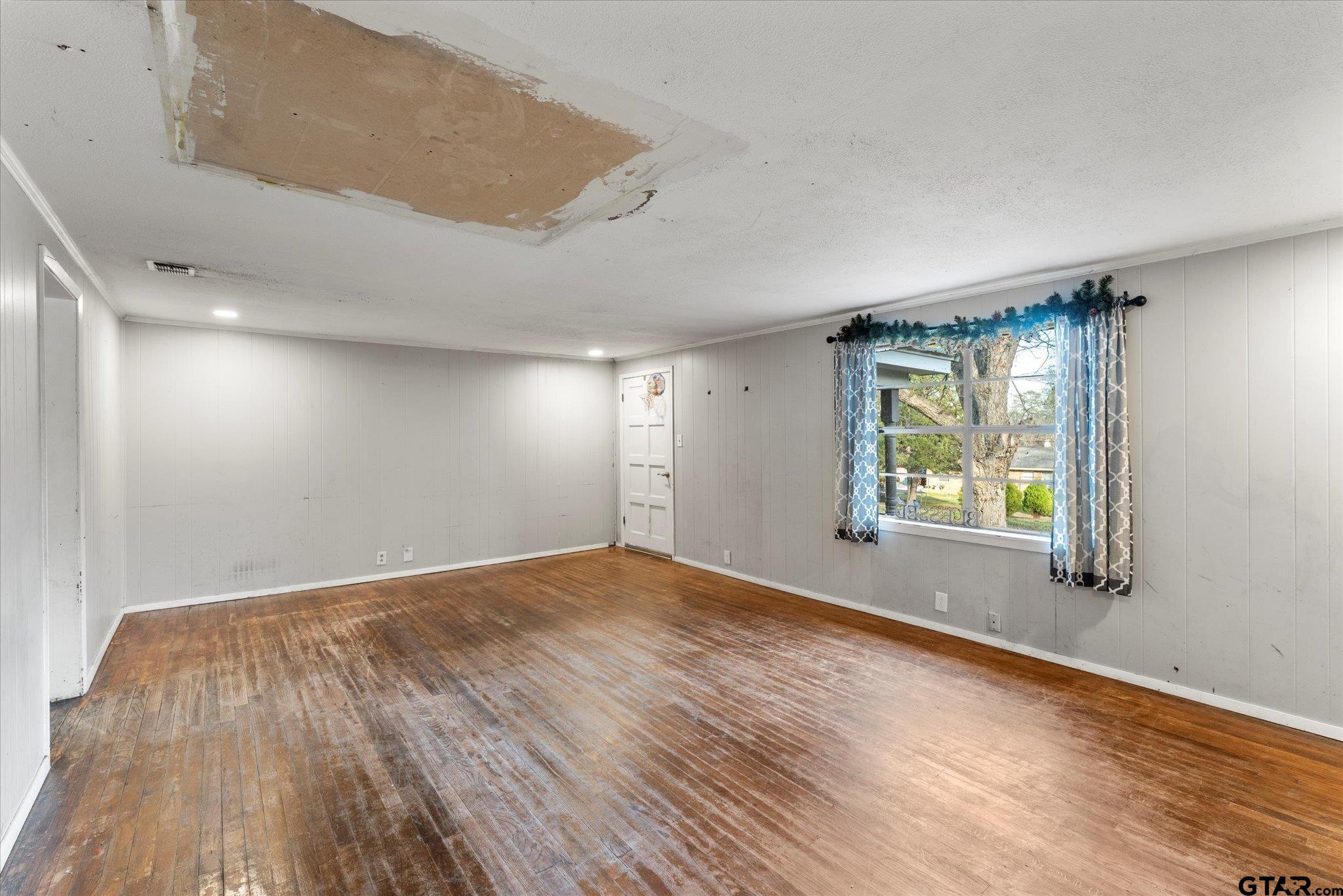 1108 Merritt Avenue Mount Pleasant, TX 75455 - Photo 6 of 17 a view of an empty room with wooden floor and a window