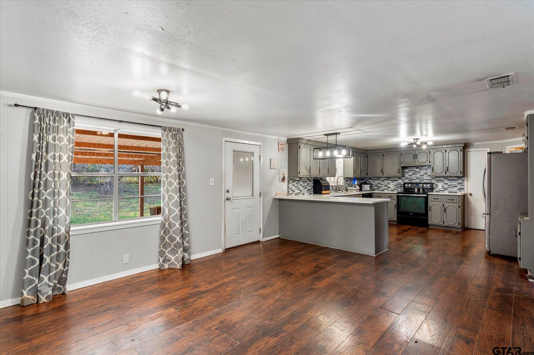 1108 Merritt Avenue Mount Pleasant, TX 75455 - Photo 8 of 17 a view of kitchen with refrigerator and wooden floor