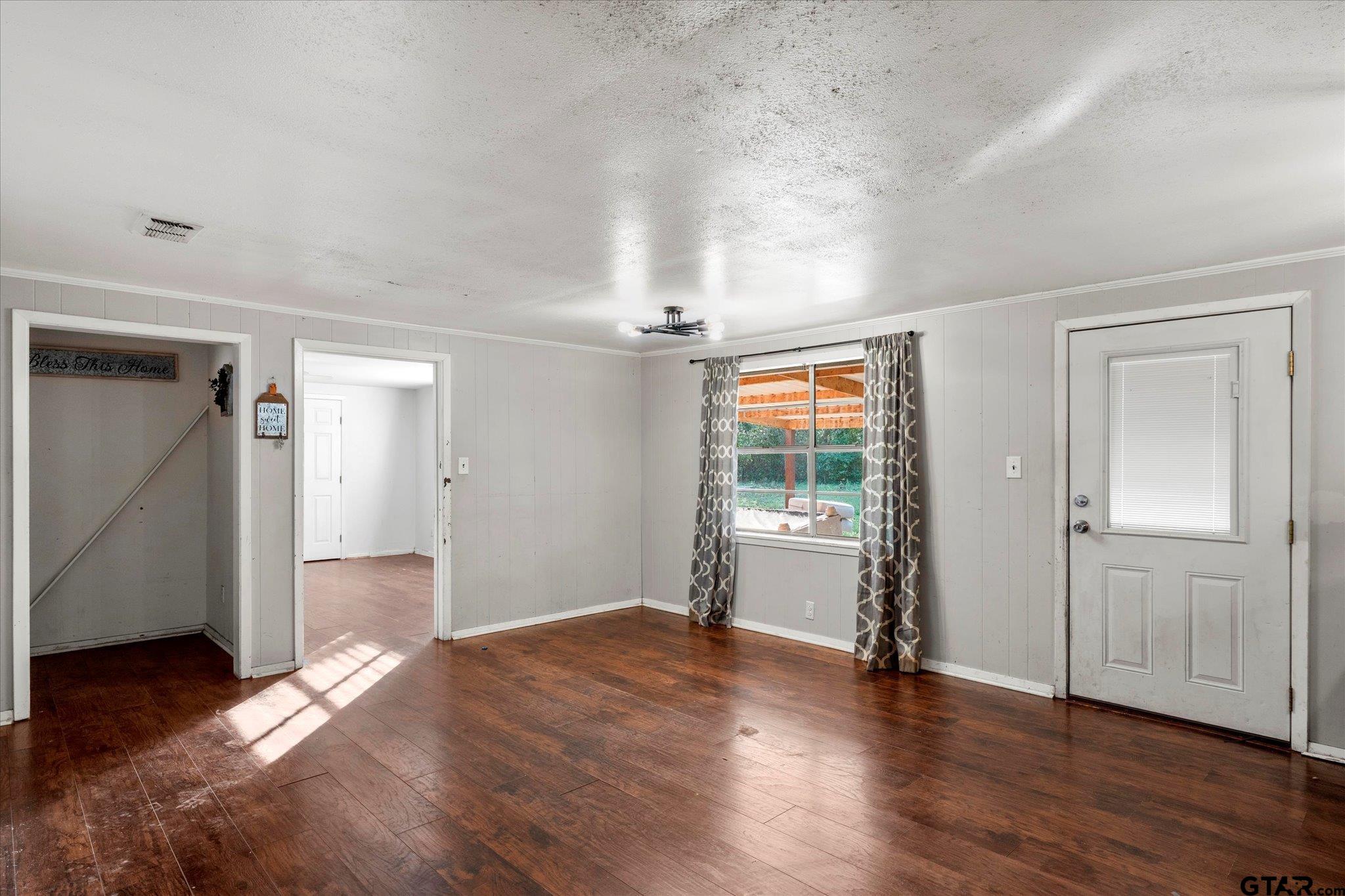 1108 Merritt Avenue Mount Pleasant, TX 75455 - Photo 9 of 17 an empty room with wooden floor and windows