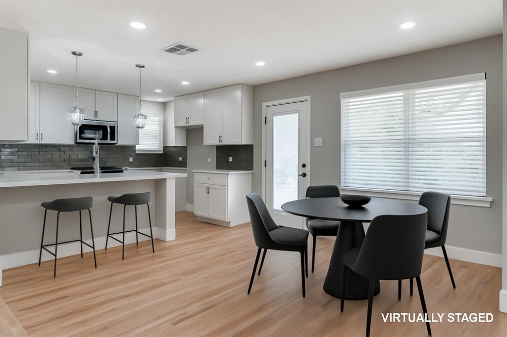 2542 Delmac Drive Dallas, TX 75233 - Photo 7 of 20 a kitchen with stainless steel appliances kitchen island granite countertop a dining table chairs and a refrigerator